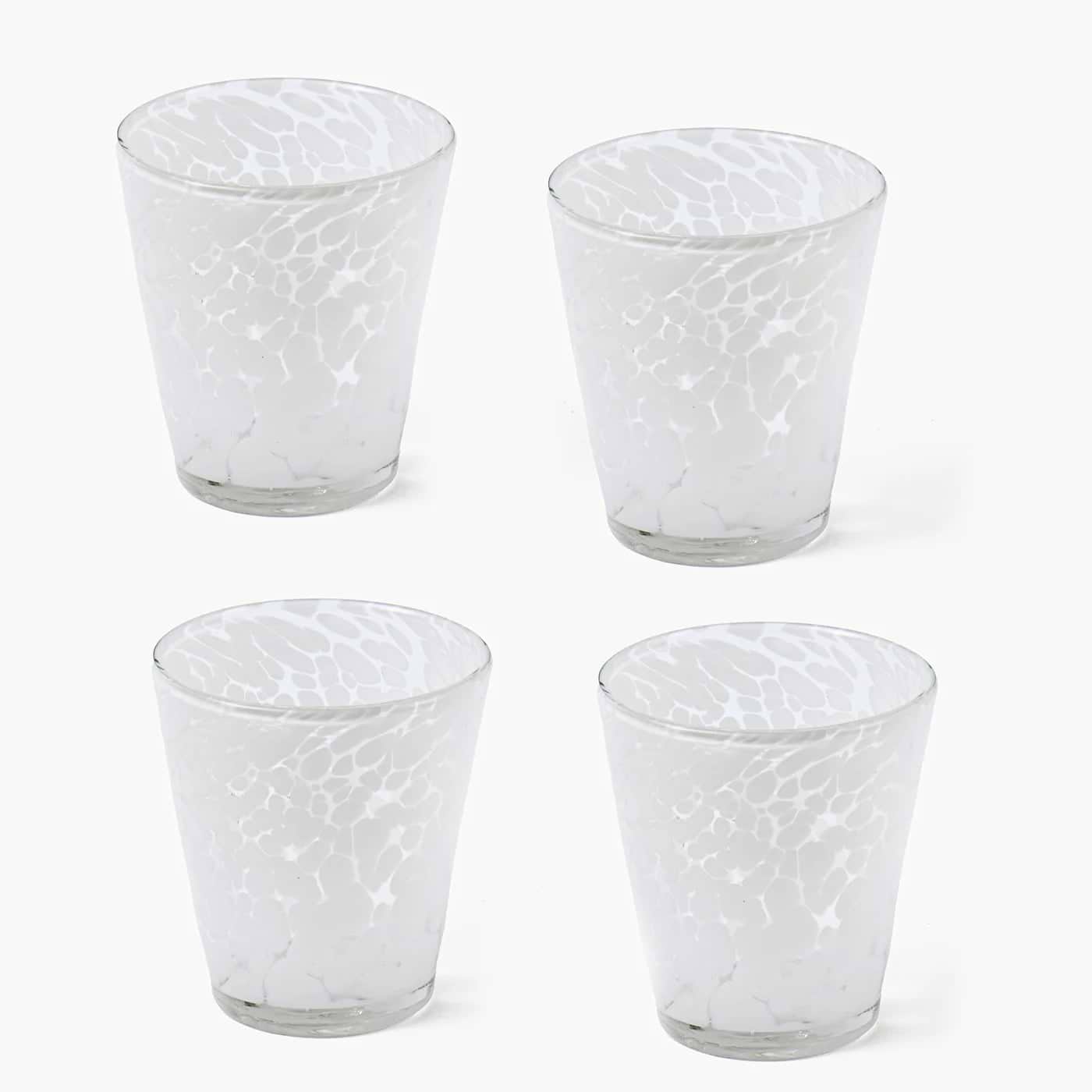 Four textured glass tumblers on a white background