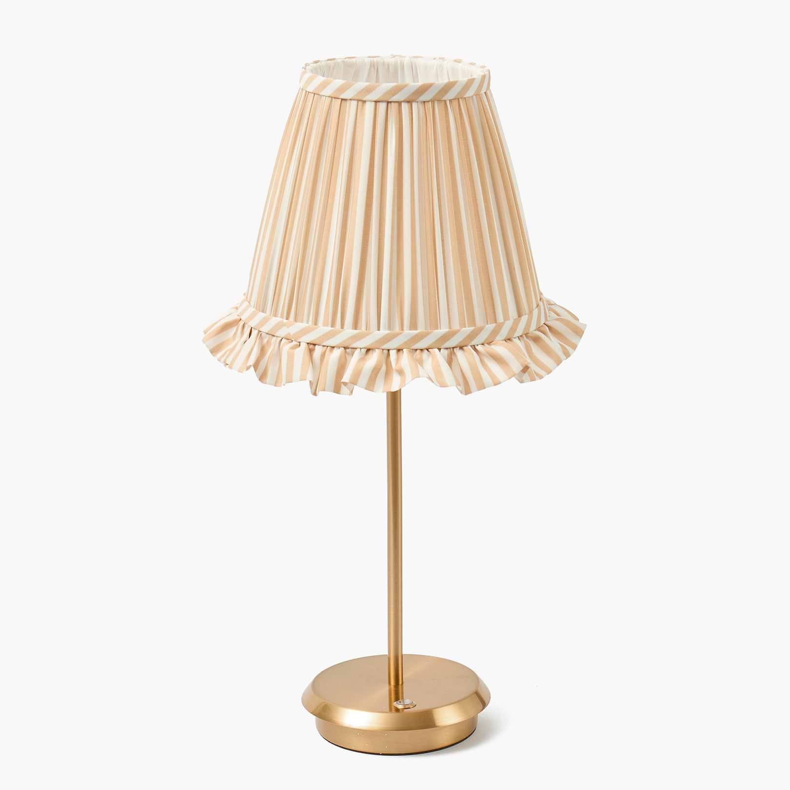 Table lamp with a striped beige and white shade on a white background