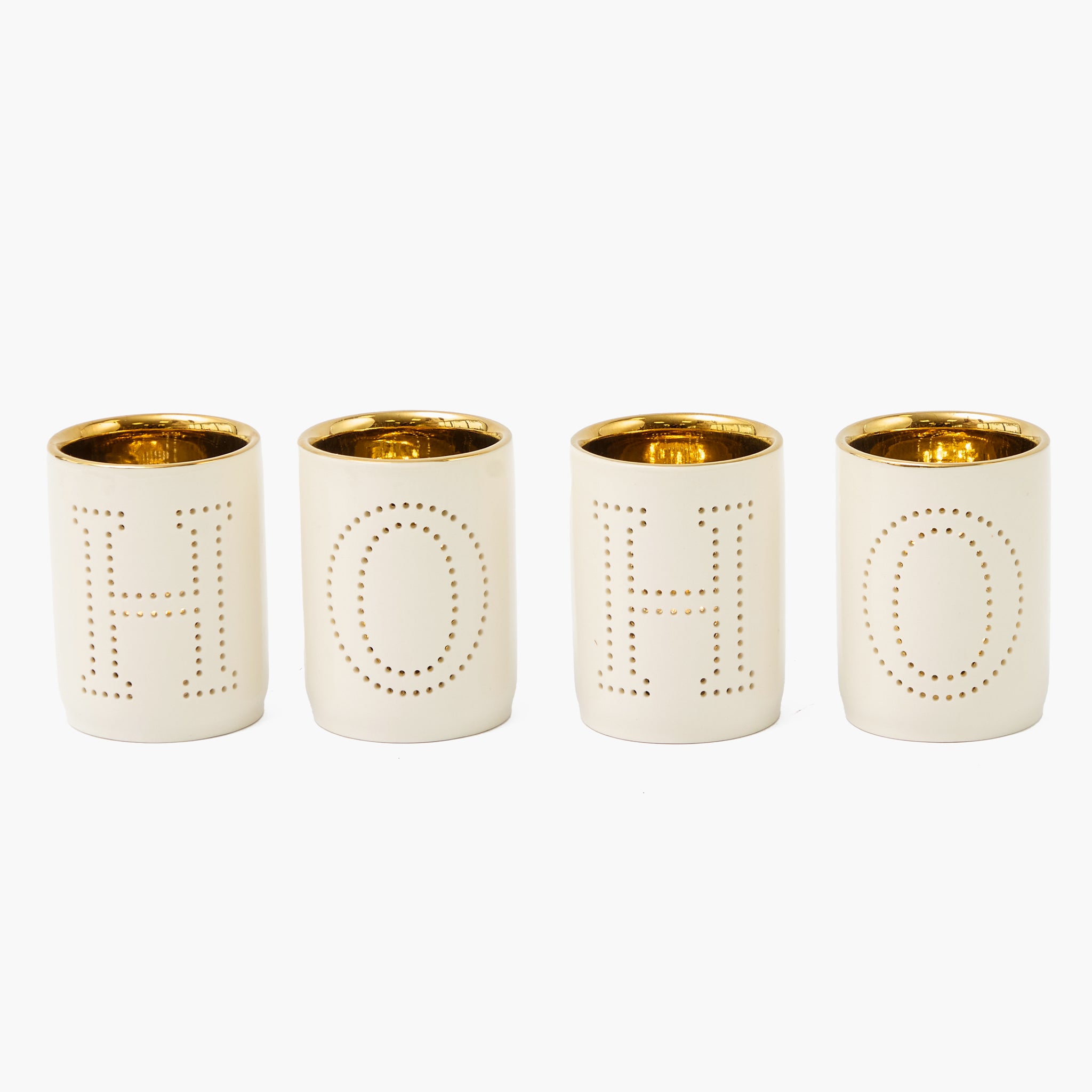 Four tealight cups with gold rims and lettering on a white background