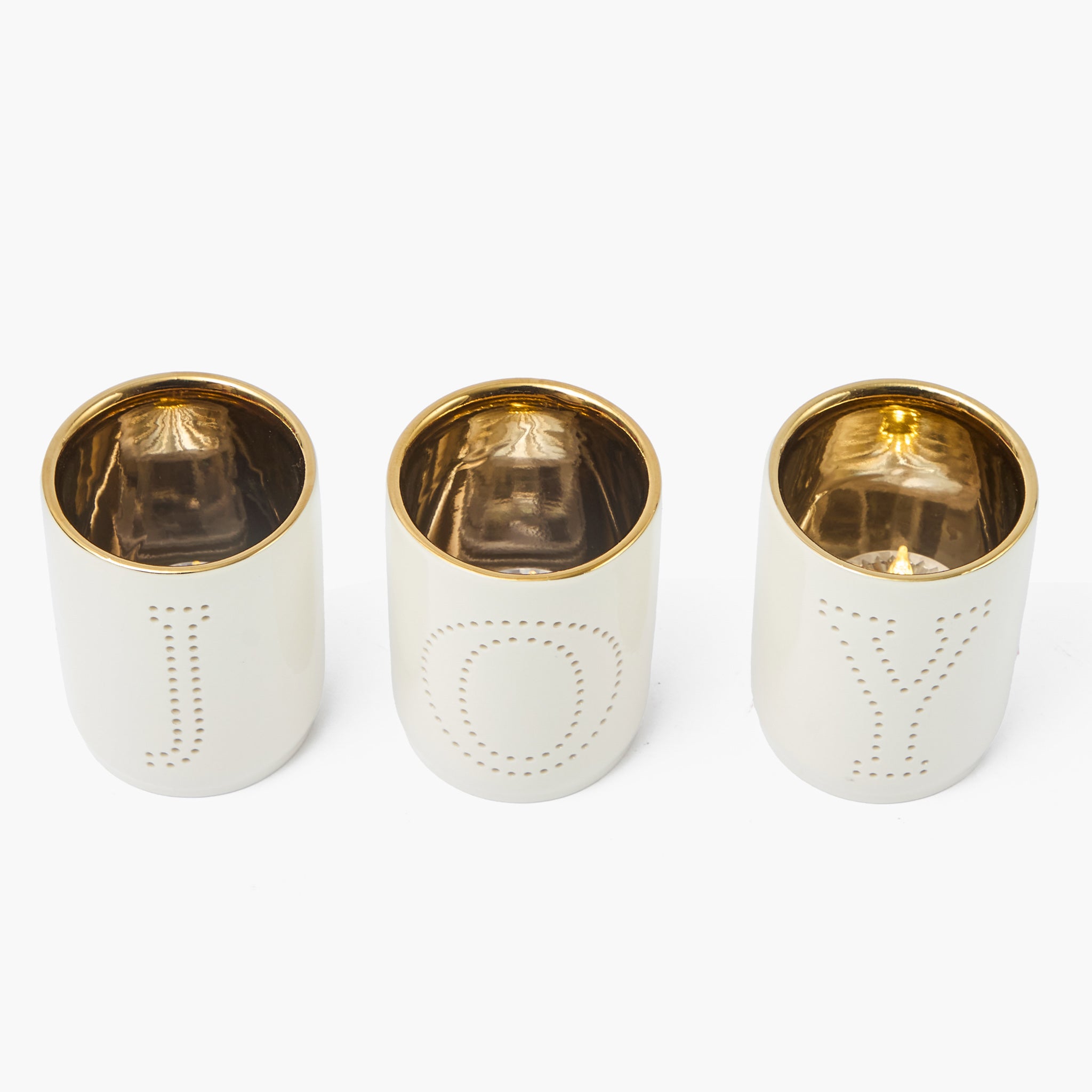 Three white candle holders with gold rims on a white background