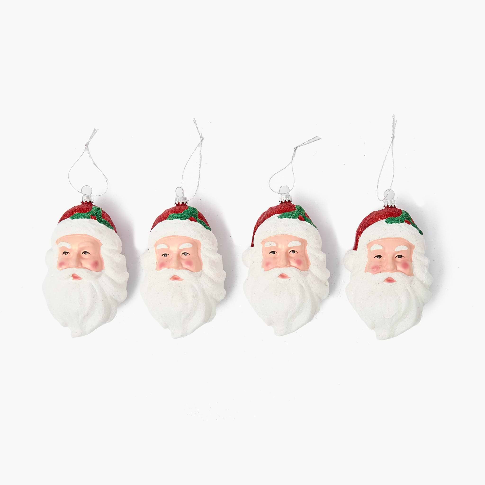 Four Santa Claus face ornaments hanging against a white background