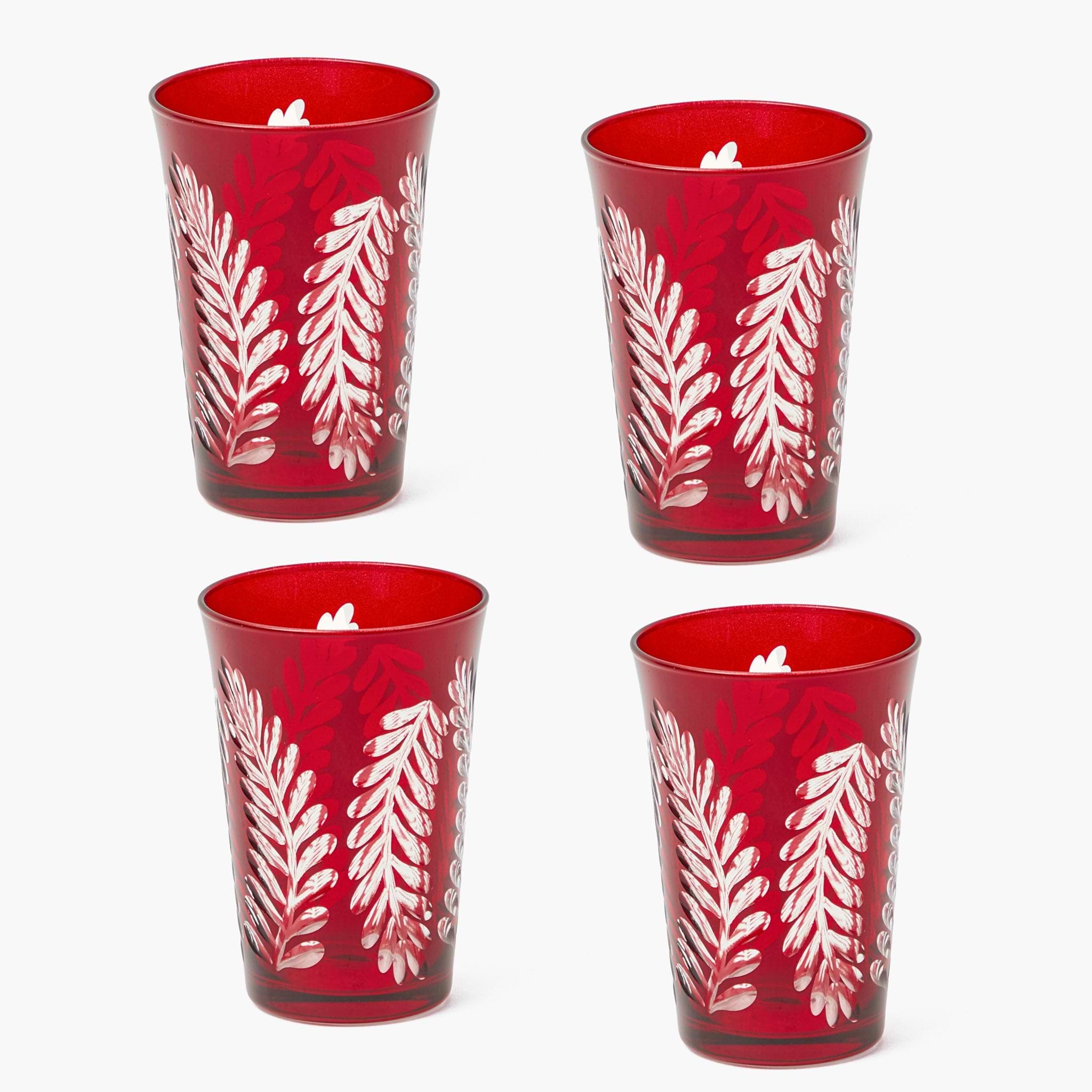 Four red candle holders with white leaf patterns on a white background