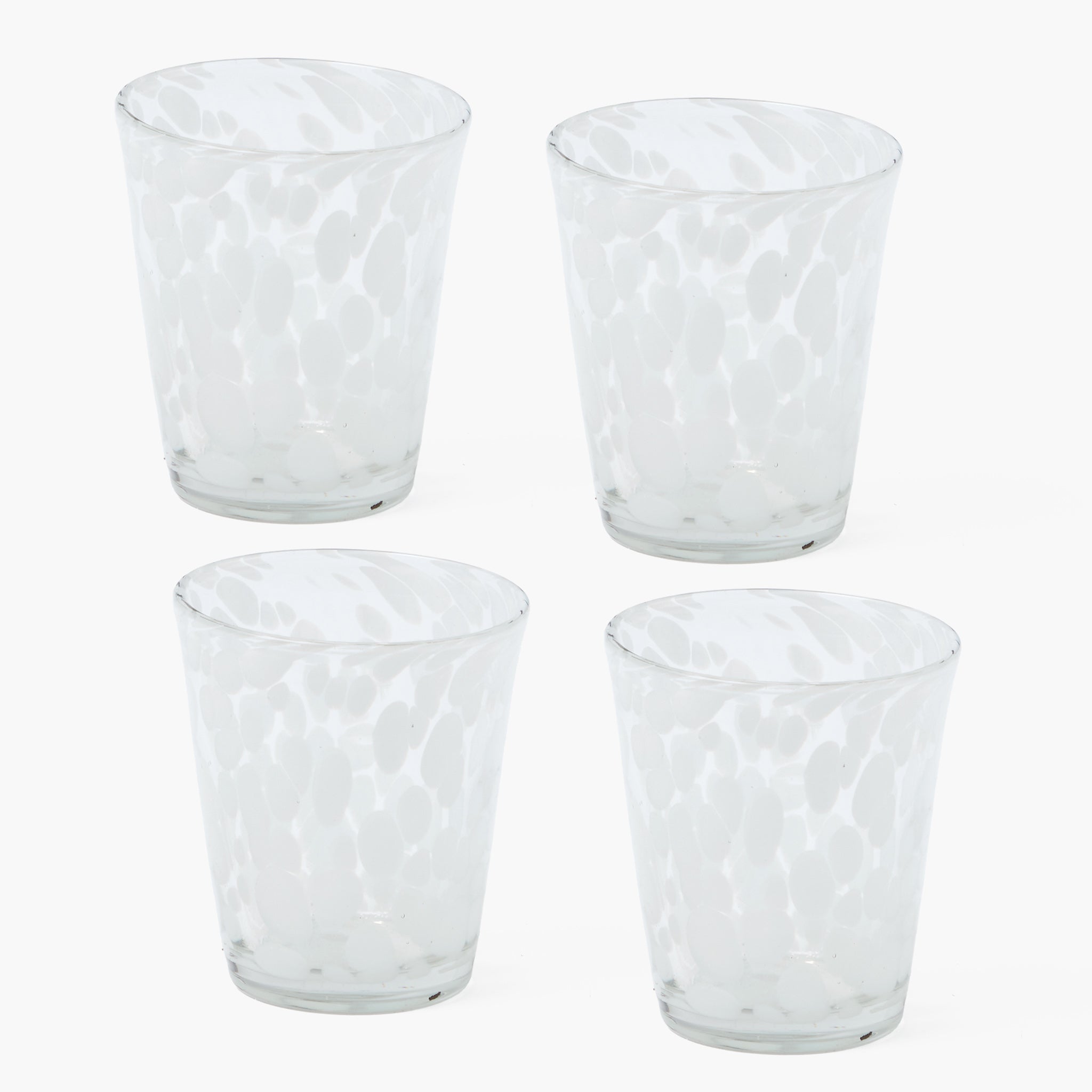 Four clear glass tumblers with textured design on a white background