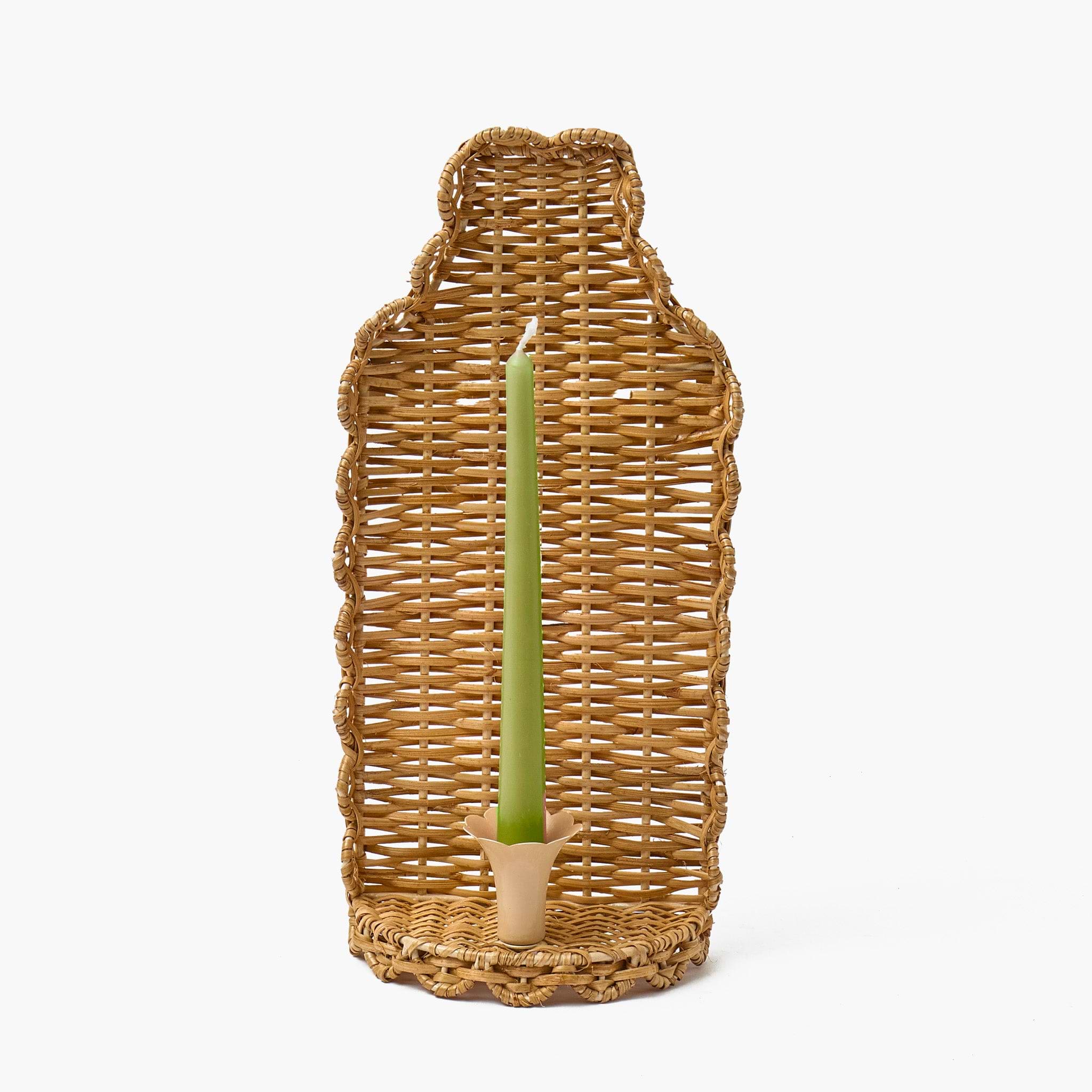 Wicker candle holder with a pink candle on a white background