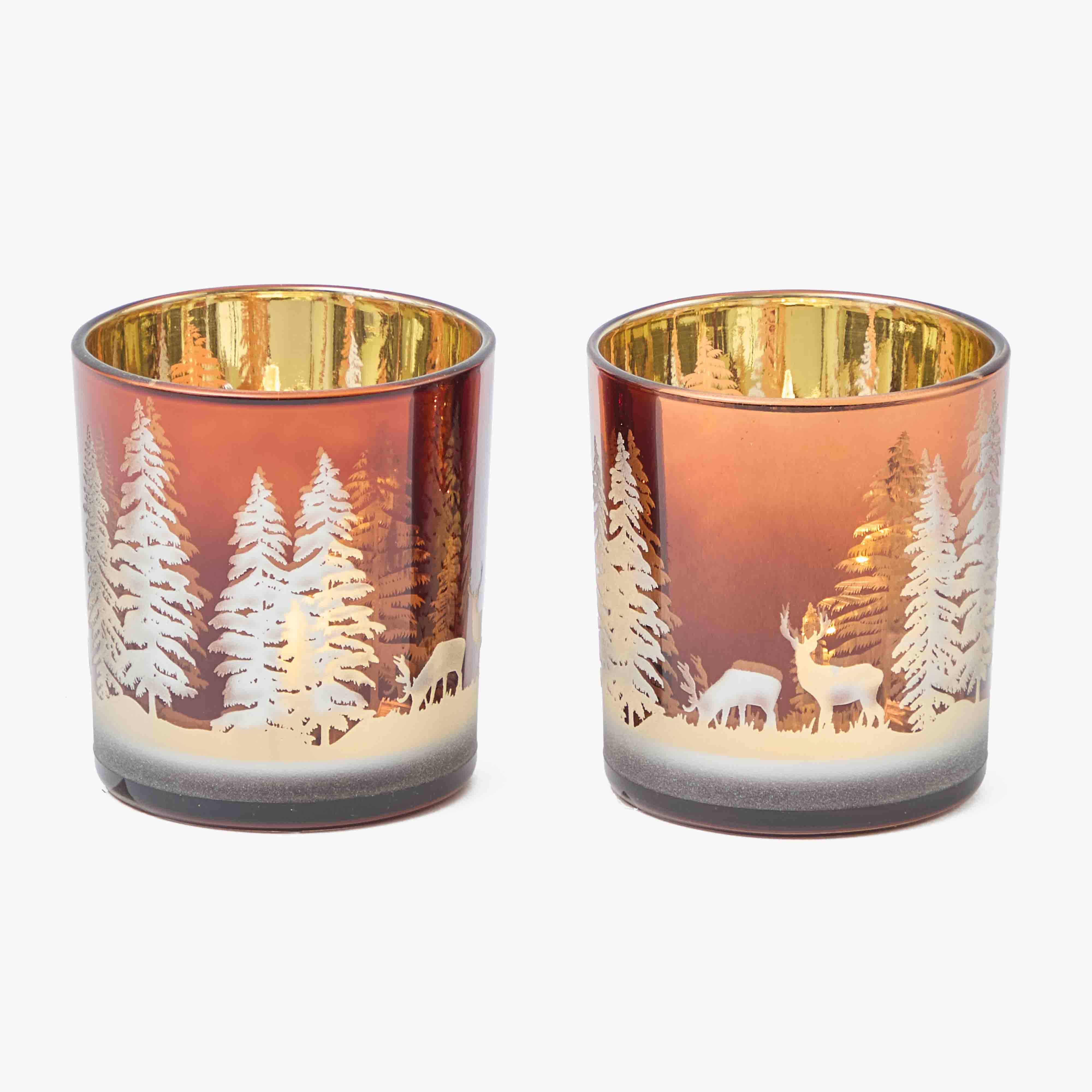 Two glass candle holders with deer and forest design on a white background