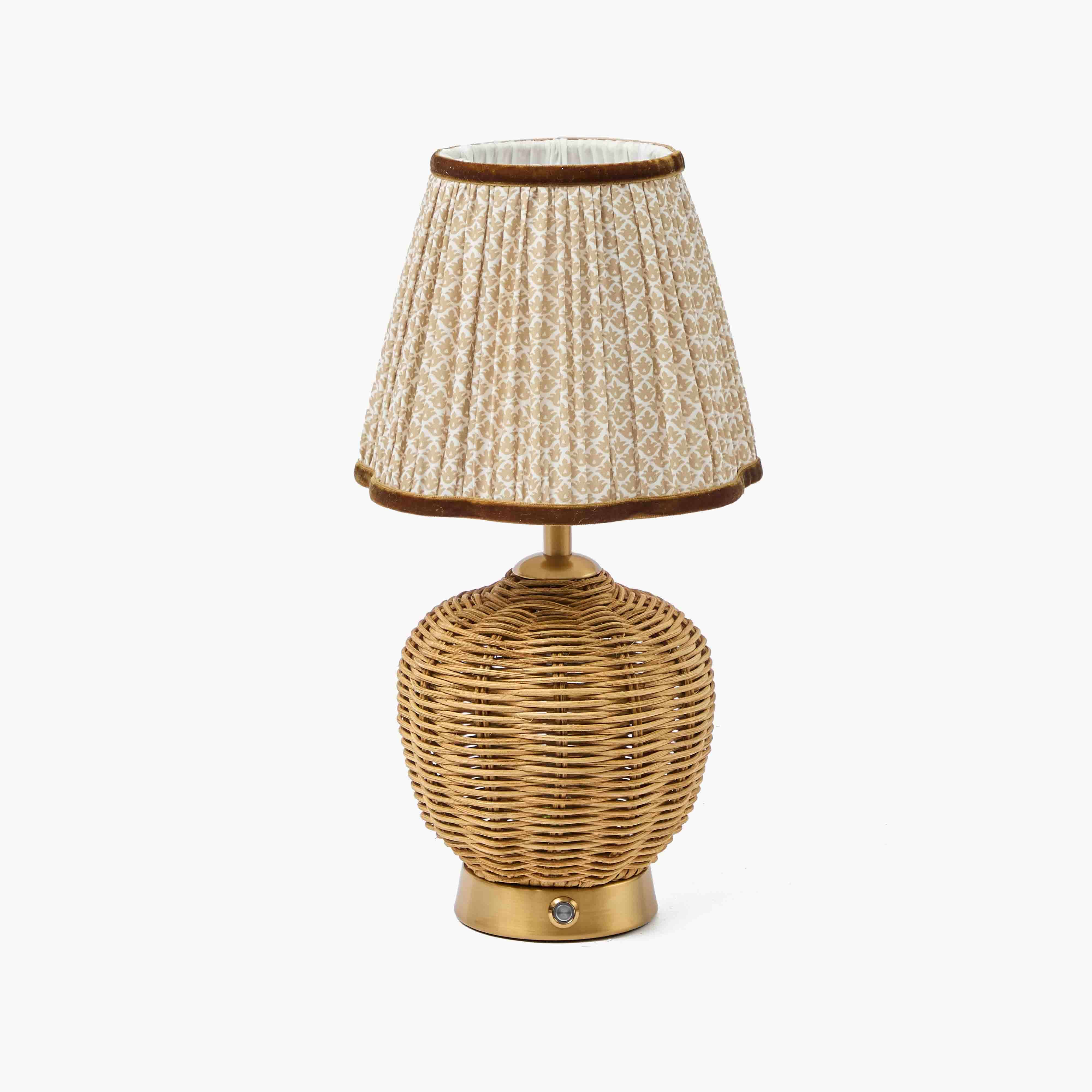 Table lamp with wicker base and textured fabric shade on a white background