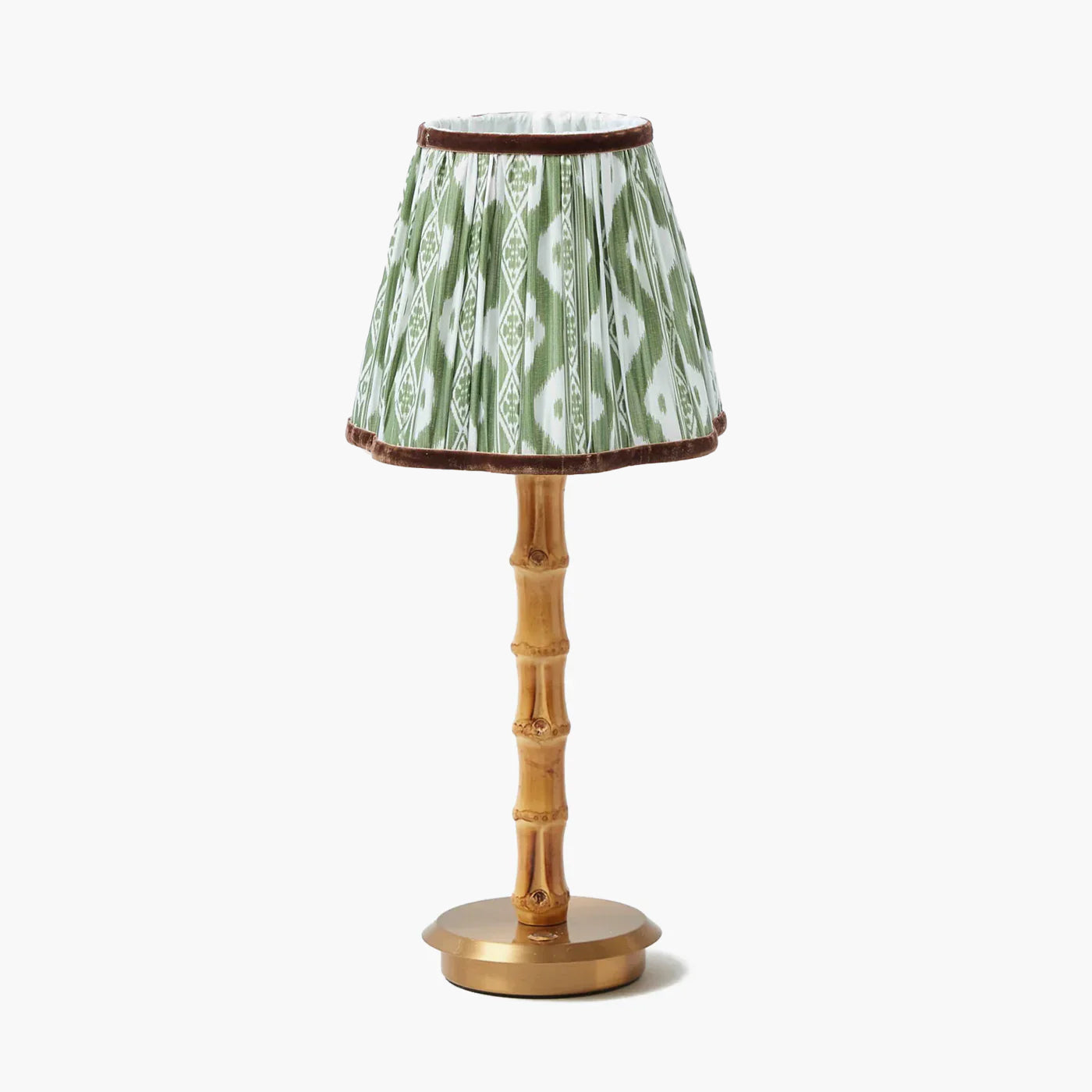 Small lamp with a green ikat patterned shade and gold base on a white background