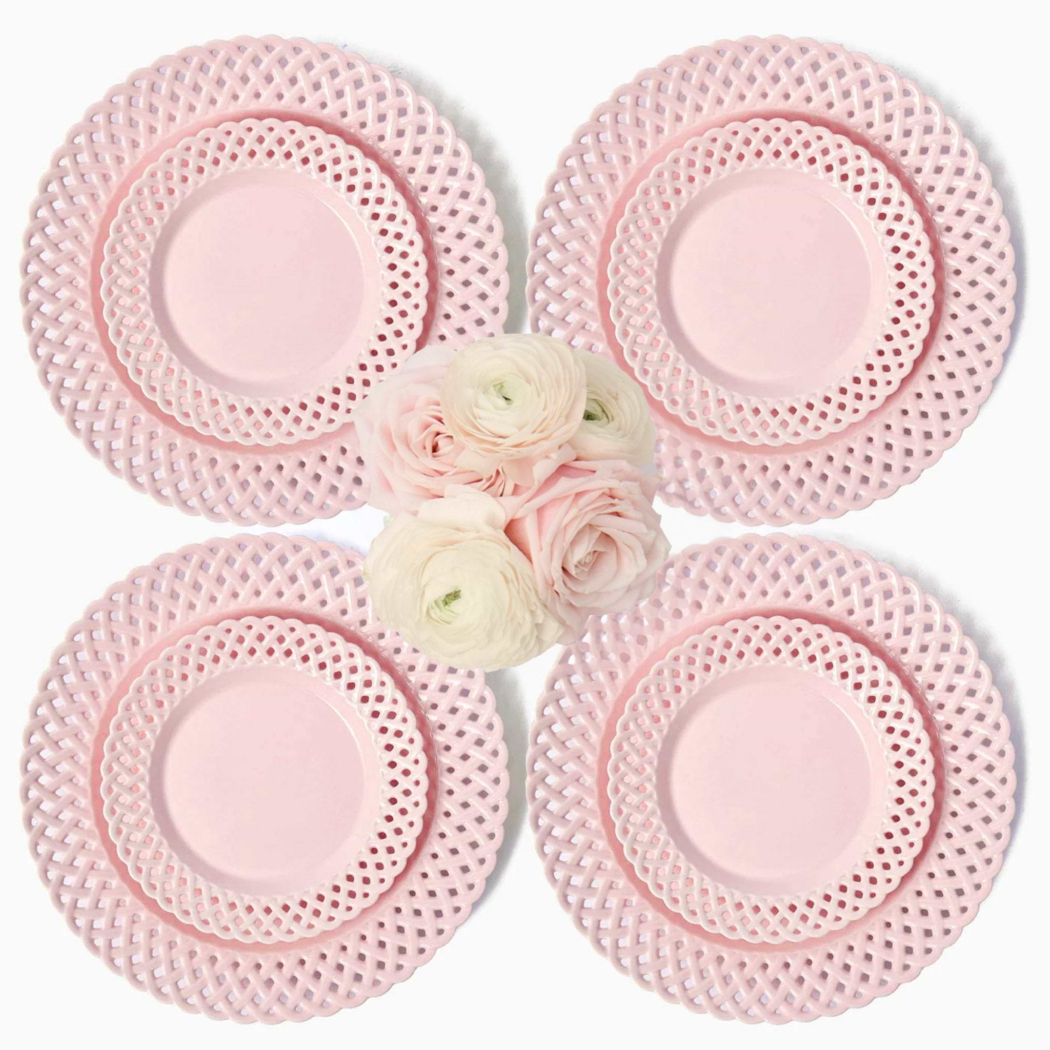 Set of four pink lace plates with a small bouquet of flowers in the center on a white background