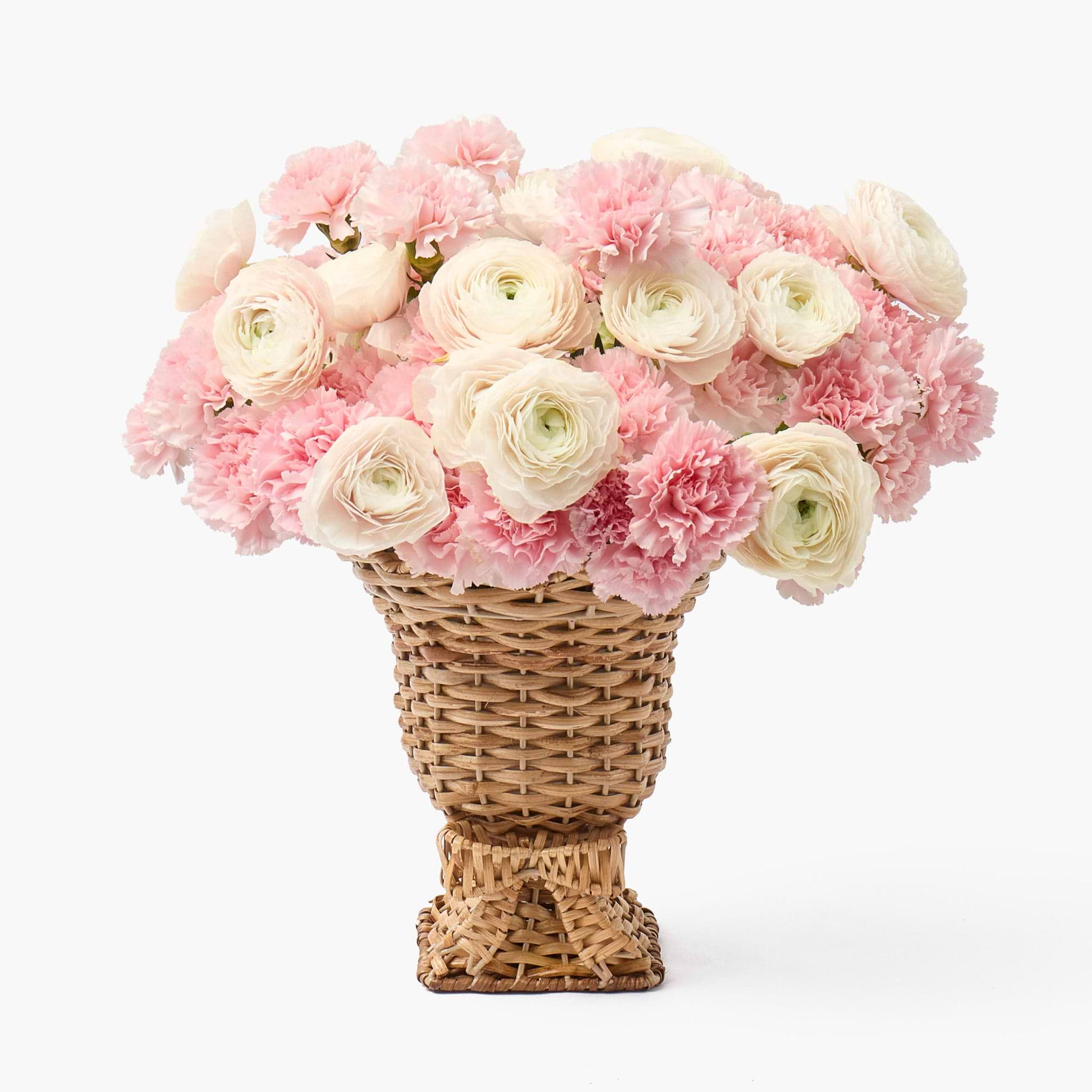 Wicker basket filled with pink and white flowers on a white background