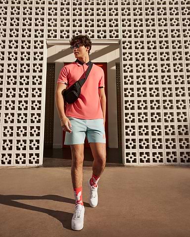 walking model wearing psycho bunny polo and short with sneakers