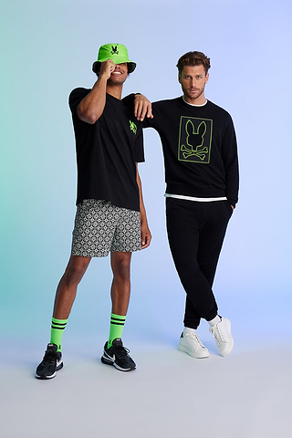 two guys standing next to each other on a blue background