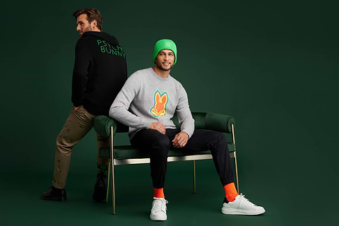 Fondo verde con dos modelos con suéteres.