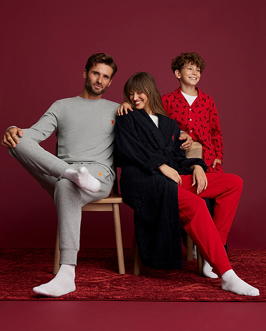 a family sitting together. one man, a woman and a kid wearing loungewear