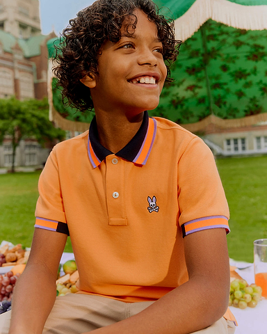 kids smiling wearing an orange psycho bunny polo