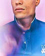 Mens Aram Pique Polo in blue, with a classic fit, pique texture, white collar trim, two-button placket with white buttons, and a small white embroidered Psycho Bunny skull logo on the left chest. (2)