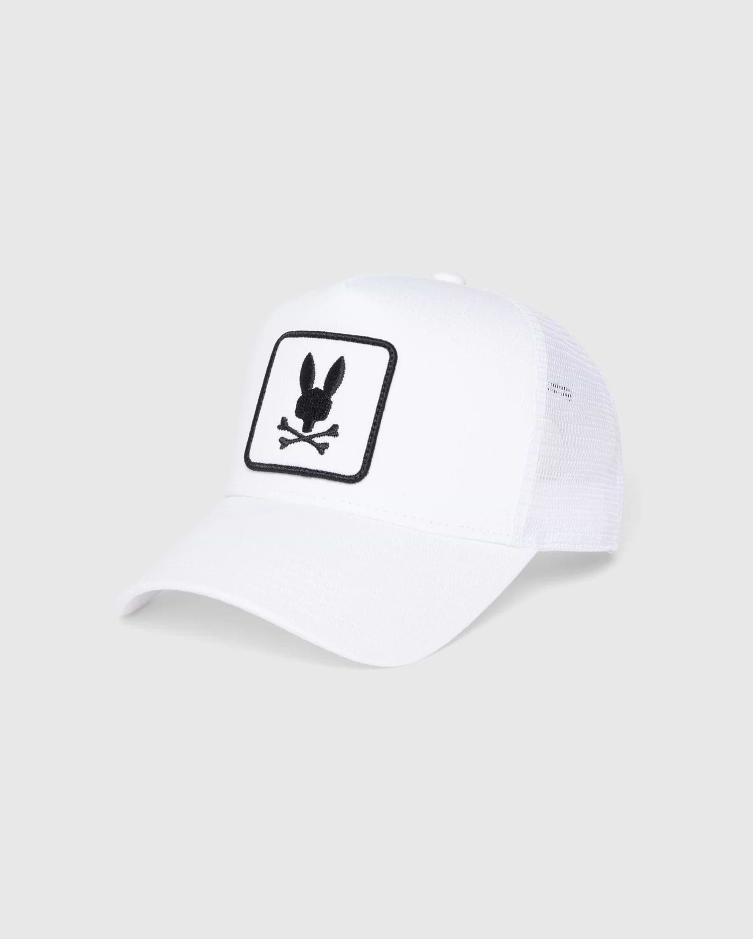 The Psycho Bunny Kids Bunny Patch Trucker Cap (B0A965C200) is a white mesh baseball cap featuring the iconic rabbit head above crossed bones emblem. This hat beautifully blends classic style with a playful design.