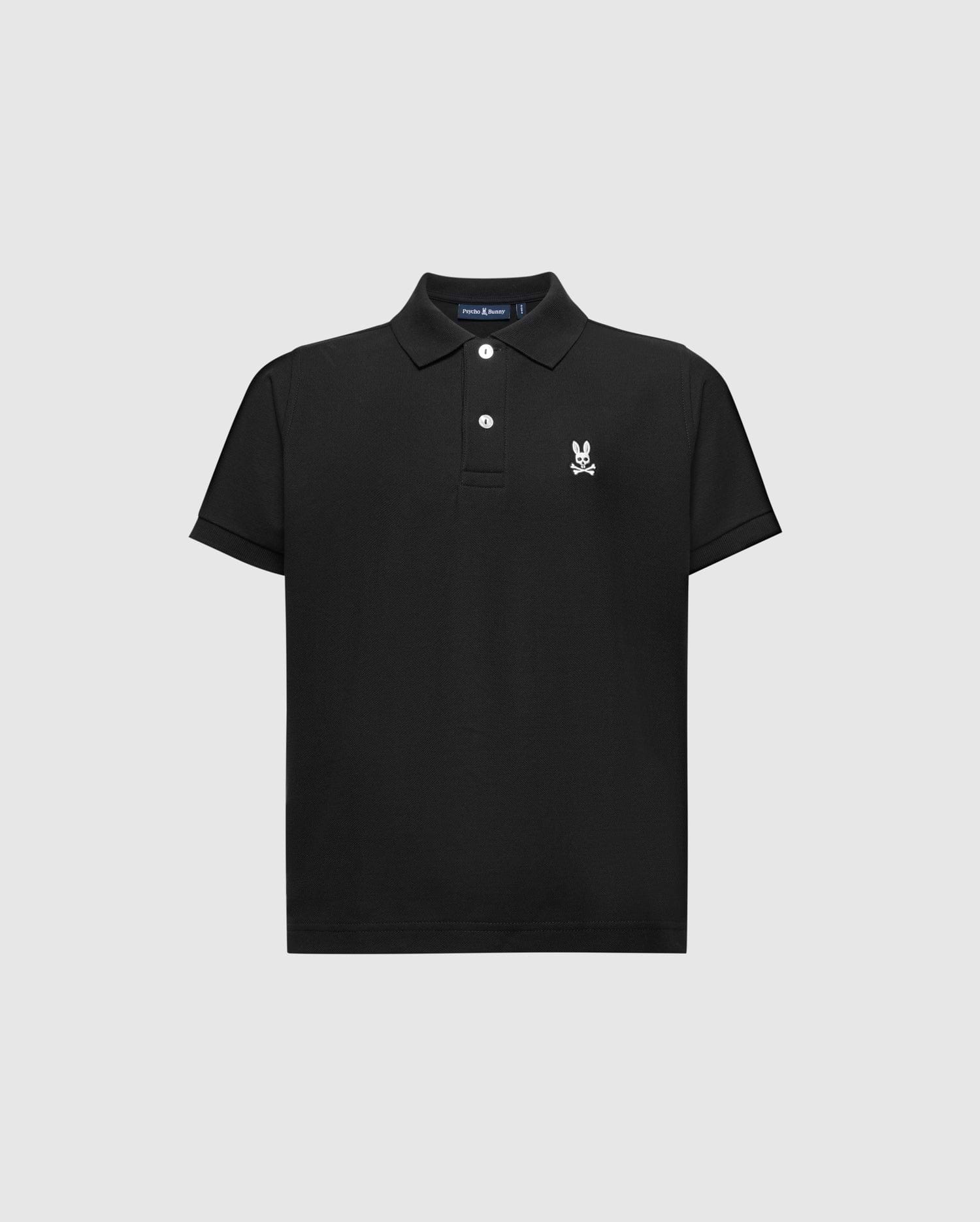 The KIDS CLASSIC PIQUE POLO SHIRT by Psycho Bunny features short sleeves, a black Pima cotton fabric, a collar with three white buttons, and the iconic small white embroidered rabbit with crossed bones on the left chest against a light gray backdrop.