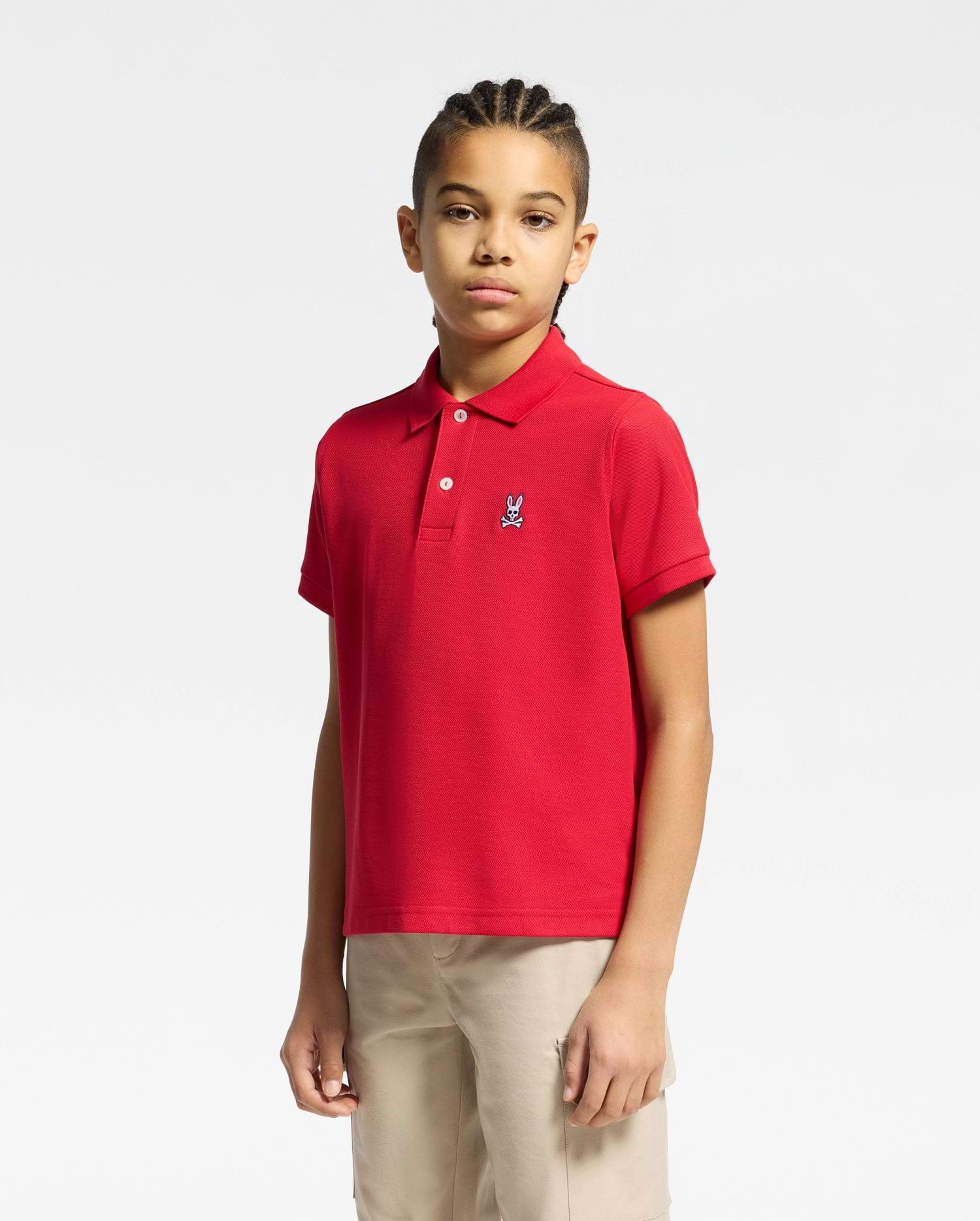 kids classic pique polo shirt in vibrant red, featuring a classic fit, two-button placket, and a small embroidered white Psycho Bunny skull logo on the left chest.