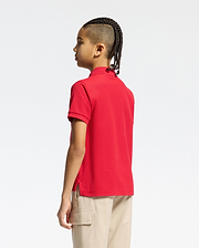 Vibrant red kids classic pique polo shirt by Psycho Bunny, showcasing a classic fit, textured pique fabric, short sleeves, ribbed collar, and subtle side vents.