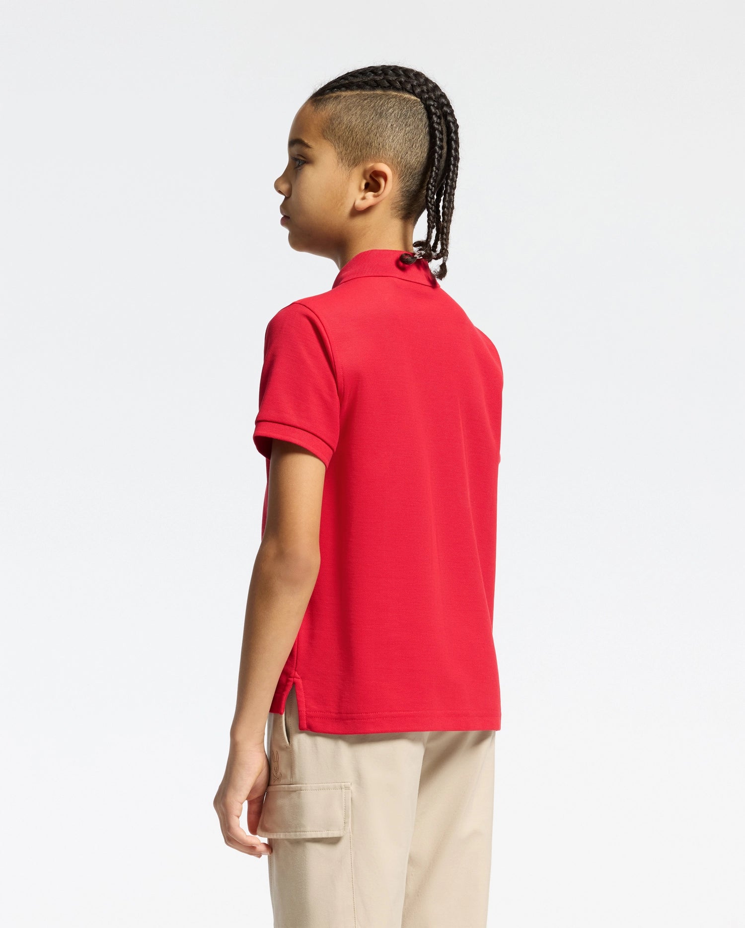 Vibrant red kids classic pique polo shirt by Psycho Bunny, showcasing a classic fit, textured pique fabric, short sleeves, ribbed collar, and subtle side vents.