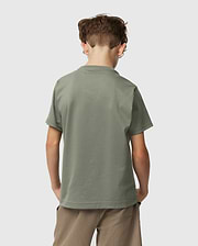 A young boy with short brown hair faces away, wearing a Psycho Bunny Kids Classic Crew Neck Tee in plain green and beige shorts. This 100% Pima cotton tee is ideal for back-to-school, set against a light grey background.