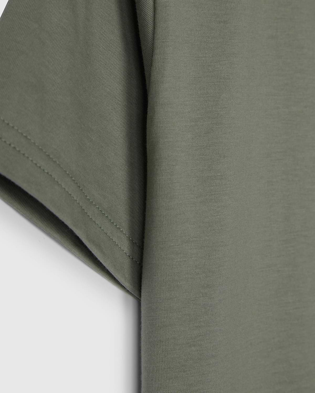 The KIDS CLASSIC CREW NECK TEE - B0U014B200 by Psycho Bunny, in olive green, showcases sleeve and side details on a plain white background. Made from 100% Pima cotton, its texture and stitching make it an ideal back-to-school choice.