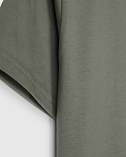 The KIDS CLASSIC CREW NECK TEE - B0U014B200 by Psycho Bunny, in olive green, showcases sleeve and side details on a plain white background. Made from 100% Pima cotton, its texture and stitching make it an ideal back-to-school choice.