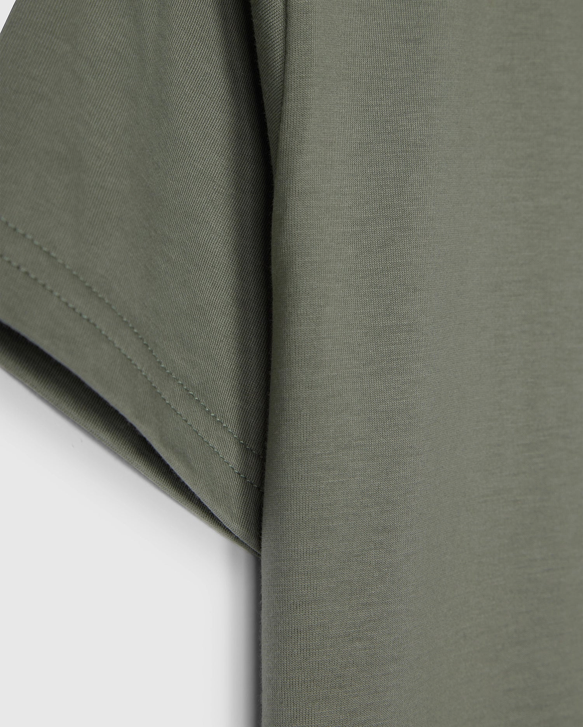 The KIDS CLASSIC CREW NECK TEE - B0U014B200 by Psycho Bunny, in olive green, showcases sleeve and side details on a plain white background. Made from 100% Pima cotton, its texture and stitching make it an ideal back-to-school choice.