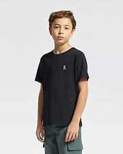 A young boy with wavy hair wears Psycho Bunny's KIDS CLASSIC CREW NECK TEE (B0U014CRPC) in black, featuring a small embroidered rabbit logo. Made from 100% Pima cotton, it pairs perfectly with his green cargo pants against the plain white background.