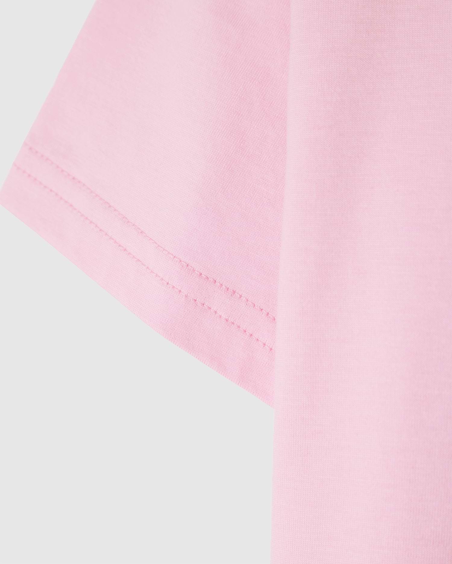 Close-up of the Psycho Bunny KIDS CLASSIC CREW NECK TEE - B0U014CRPC in pink, featuring visible sleeve stitching. Made from 100% Pima cotton for a soft and well-sewn finish, it's a high-quality choice perfect for back-to-school outfits.
