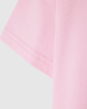Close-up of the Psycho Bunny KIDS CLASSIC CREW NECK TEE - B0U014CRPC in pink, featuring visible sleeve stitching. Made from 100% Pima cotton for a soft and well-sewn finish, it's a high-quality choice perfect for back-to-school outfits.