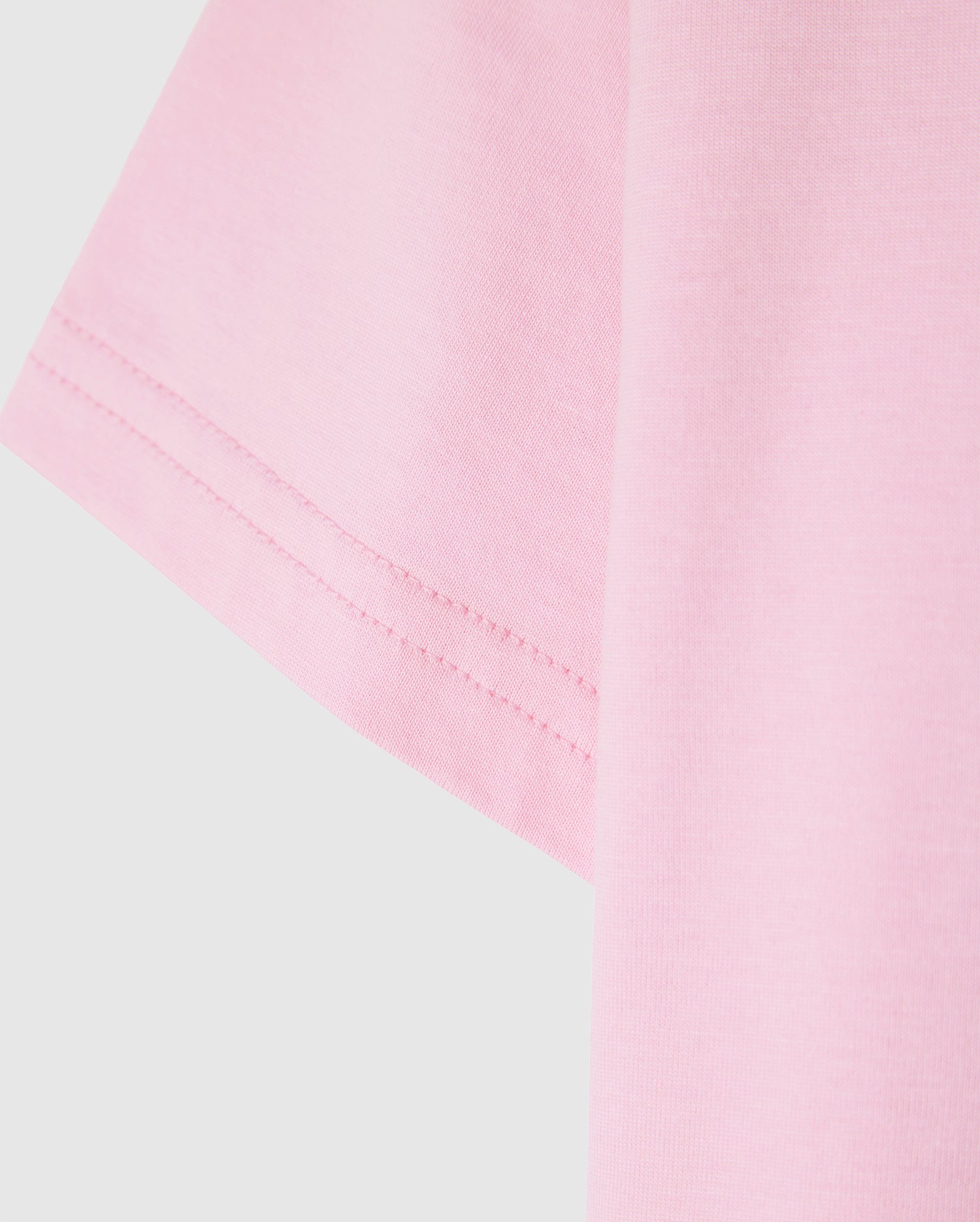Close-up of the Psycho Bunny KIDS CLASSIC CREW NECK TEE - B0U014CRPC in pink, featuring visible sleeve stitching. Made from 100% Pima cotton for a soft and well-sewn finish, it's a high-quality choice perfect for back-to-school outfits.