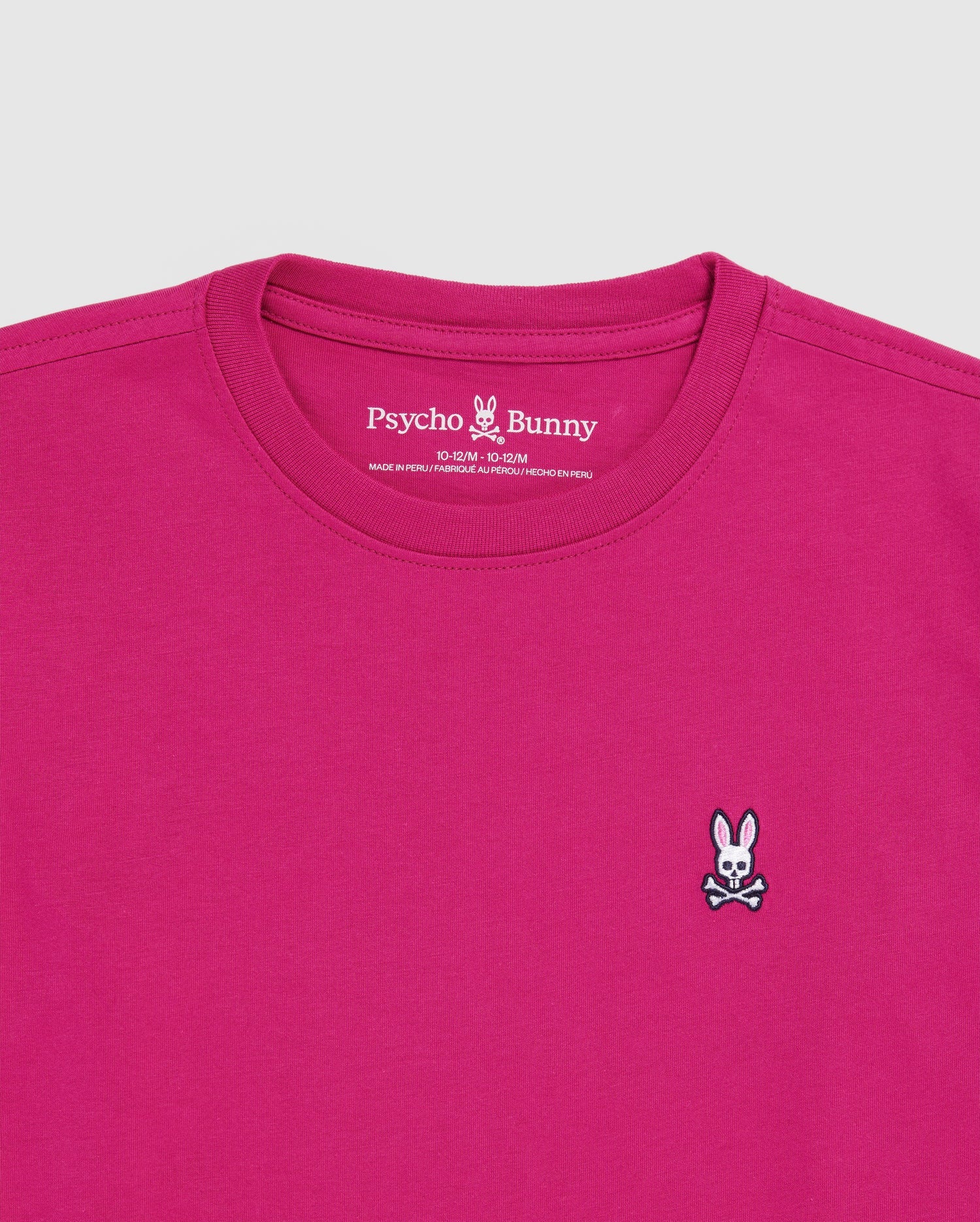 The KIDS CLASSIC CREW NECK TEE (B0U014CRPC) by Psycho Bunny is a magenta Pima cotton crewneck featuring a small embroidered white bunny with crossbones on the left chest and the brand name printed inside the collar.
