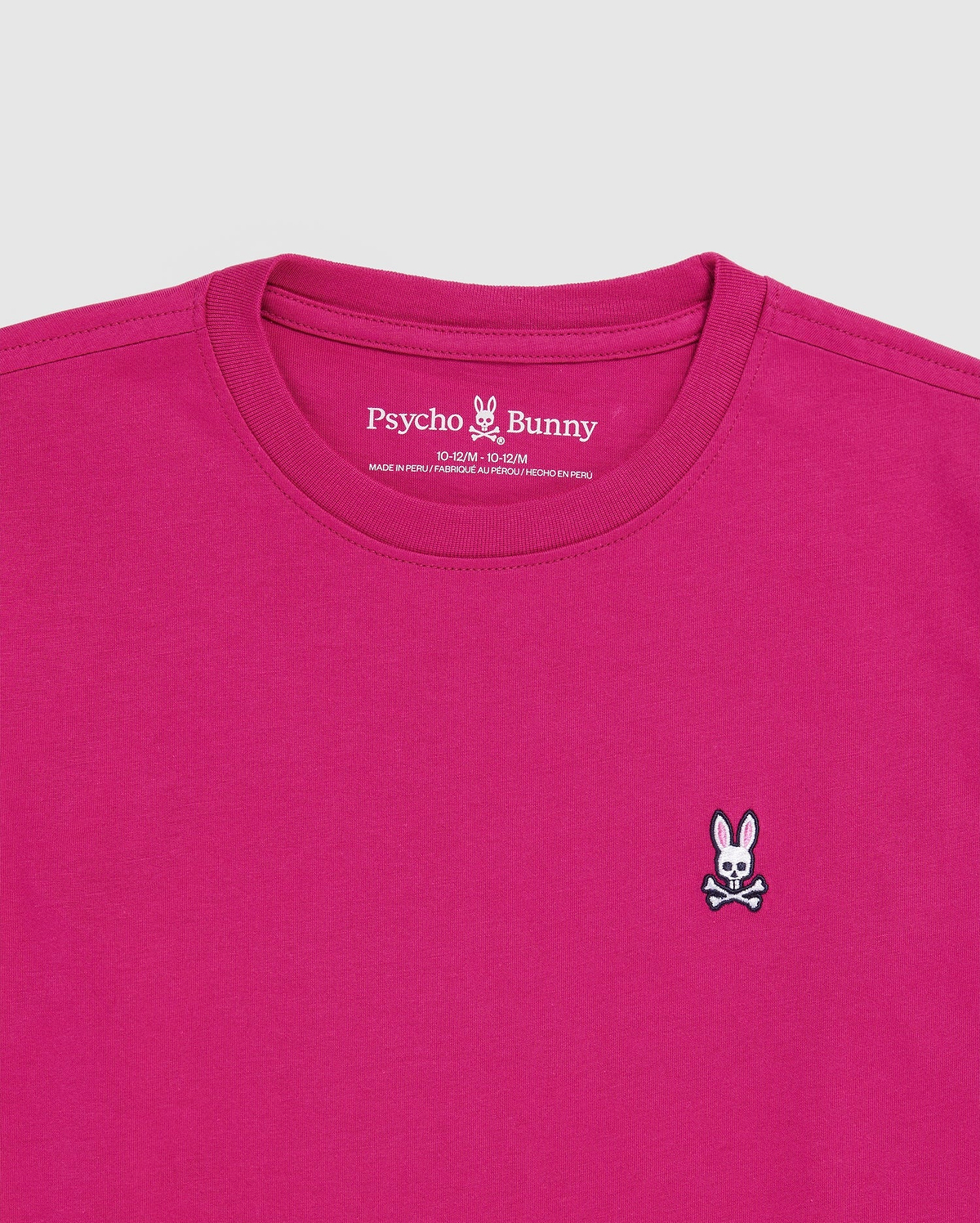 The KIDS CLASSIC CREW NECK TEE (B0U014CRPC) by Psycho Bunny is a magenta Pima cotton crewneck featuring a small embroidered white bunny with crossbones on the left chest and the brand name printed inside the collar.
