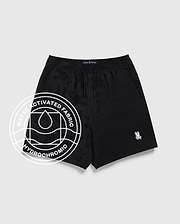 The Psycho Bunny KIDS MALTA HYDROCHROMIC SWIM TRUNK (B0W321B2SW) features a black camo pattern, white Psycho Bunny logo on the left leg, and a circular “Water Activated Fabric Hydrochromic” graphic, shown on a light gray background.