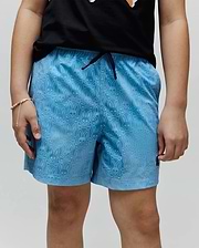 Kids Samos Hydrochromic Printed Swim Trunk in light blue, featuring an all-over tonal Psycho Bunny skull and crossbones pattern, dark blue drawstring, and small embroidered logo on the lower left leg.
