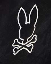 A black background with a white graphic design featuring the silhouette of a bunny's head, complete with large upright ears, positioned above two crossed bones. Perfect for customizing your waterproof bag or Psycho Bunny KIDS PARKER HYDROCHROMIC SWIM TRUNK - B0W646C200.