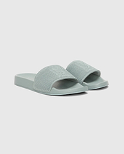 The Psycho Bunny MENS KNIT SLIDES - B6A474F200 are light green textured pool slides with open toes, a wide strap, and an ergonomically molded footbed, shown on a plain white background.