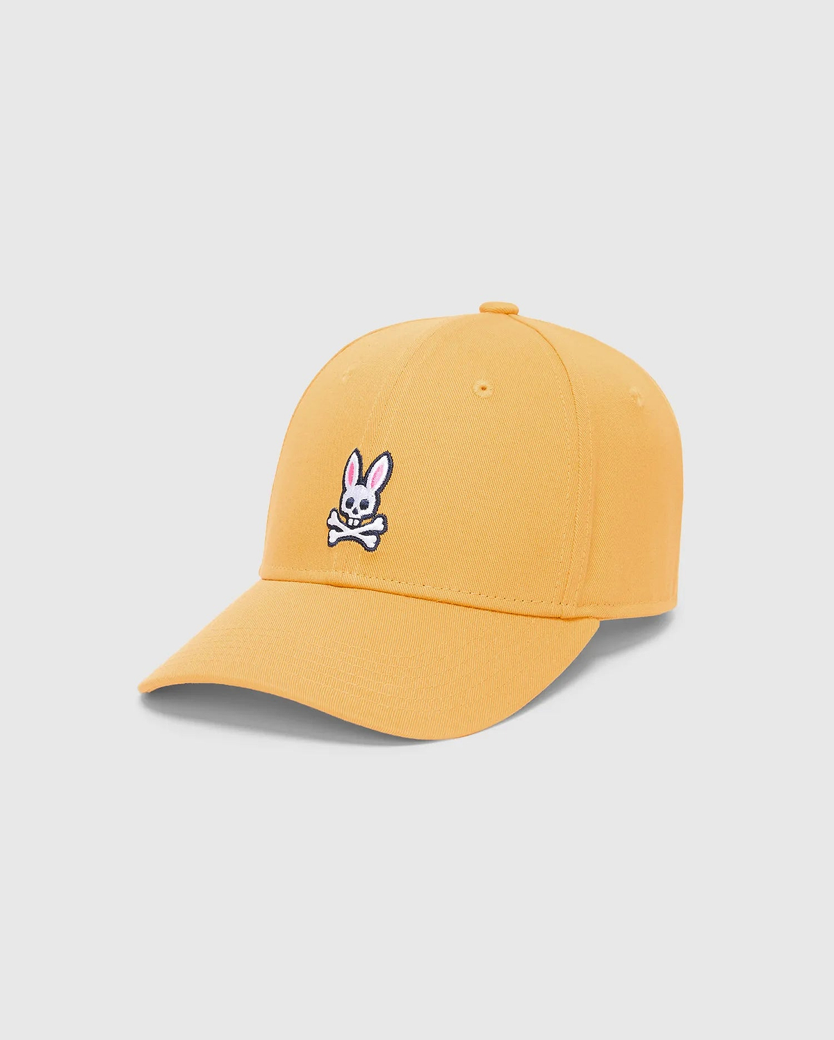 Mens Classic Baseball Cap in vibrant mustard yellow twill, featuring a prominent embroidered white, black, and pink iconic Psycho Bunny skull logo centered on the front. (3)