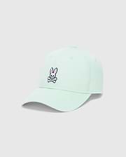 Light mint green Mens Classic Baseball Cap with a prominent embroidered pink and black Psycho Bunny skull logo on the front, featuring a classic cotton twill texture.