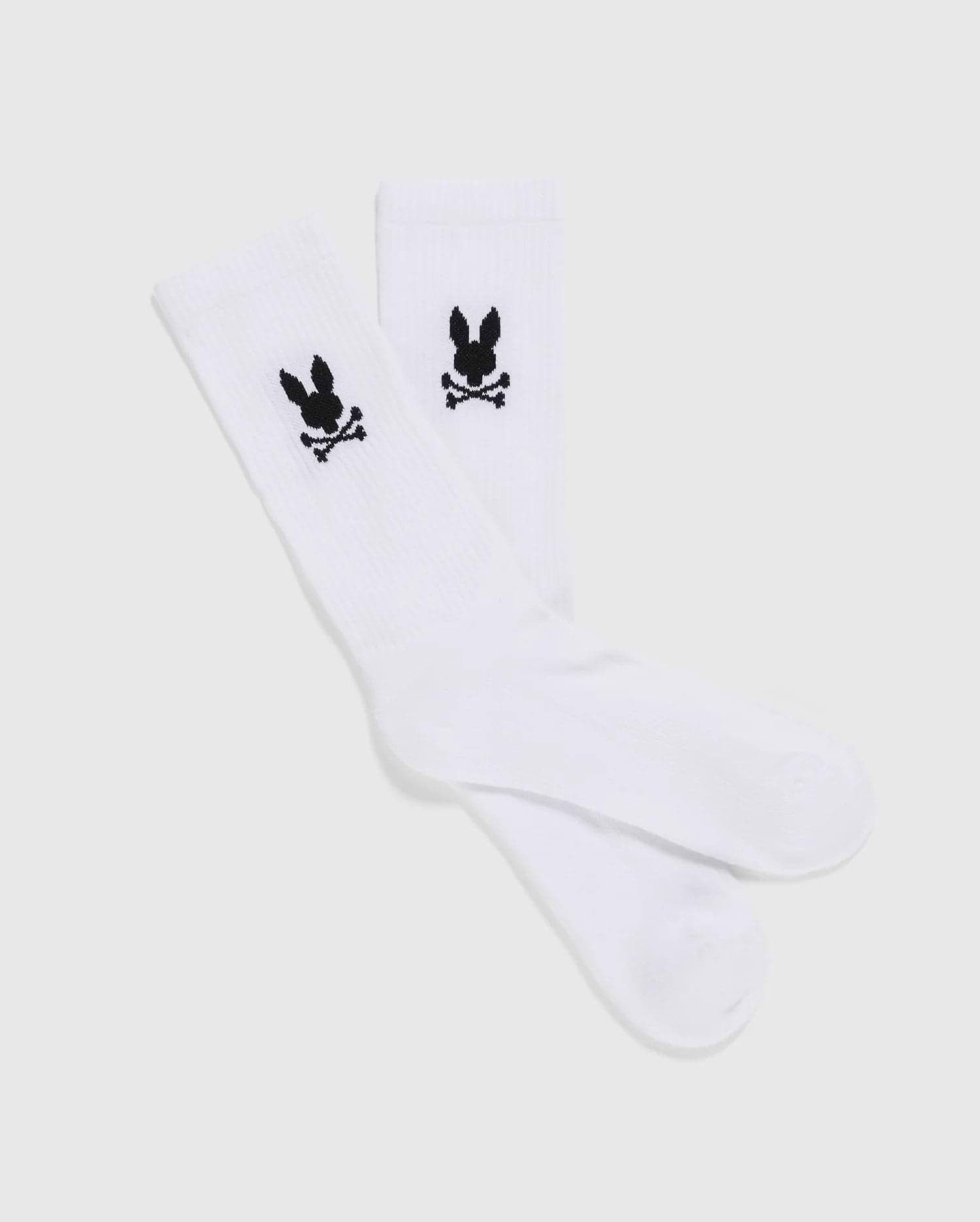 A set of 3 MENS 3 PACK SPORT SOCK - B6F997D200 by Psycho Bunny, showcasing a black skull and crossbones with bunny ears design near the top. These luxurious sport socks, crafted from Peruvian pima cotton, are displayed flat against a plain, light-gray background.