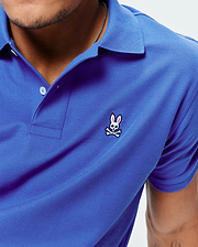 Royal blue Mens Classic Pique Polo with a classic fit, featuring a textured pique knit, white two-button placket, and a small embroidered pink and white Psycho Bunny skull logo on the left chest.
