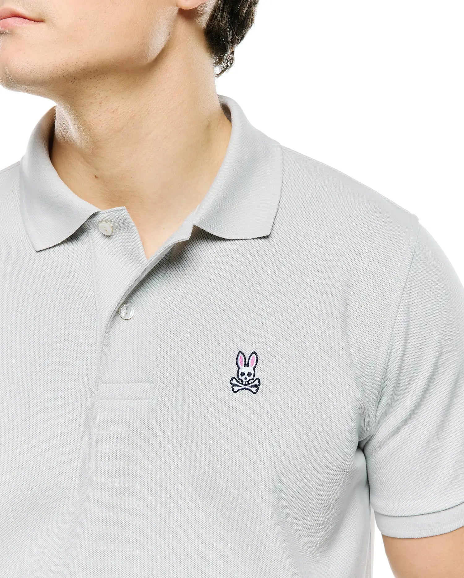 Mens Classic Pique Polo in light grey, featuring a classic fit and pique texture. Small embroidered Psycho Bunny skull logo in pink and black on the left chest. (2)