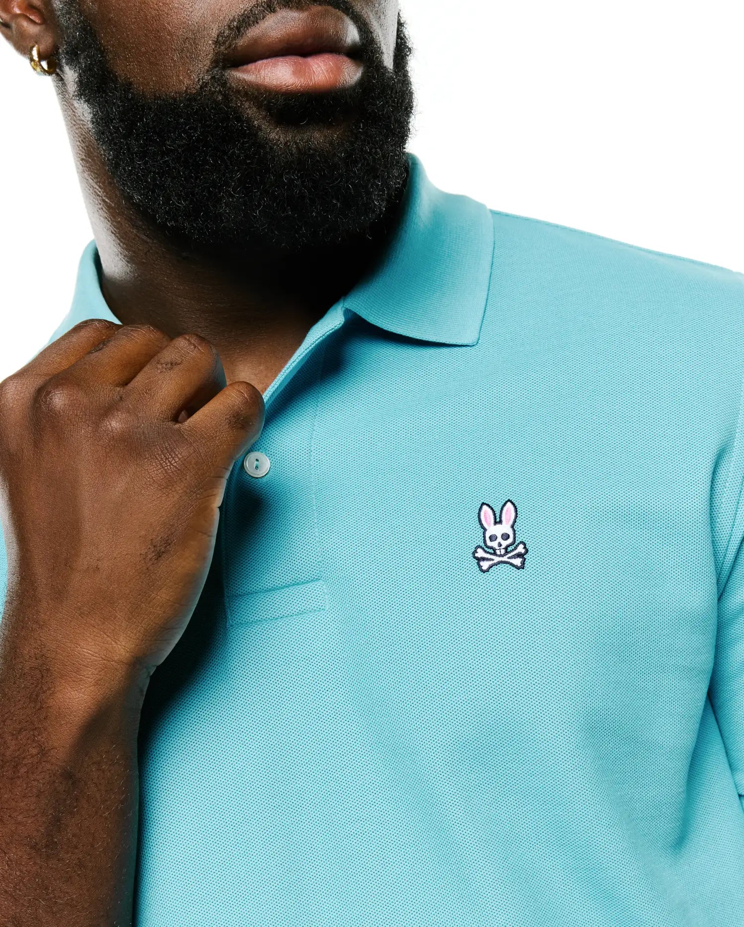 Men's Classic Pima Pique Polo in vibrant aqua, featuring a classic fit, textured pique fabric, and a small embroidered Psycho Bunny skull and crossbones logo with pink ears on the left chest. (3)