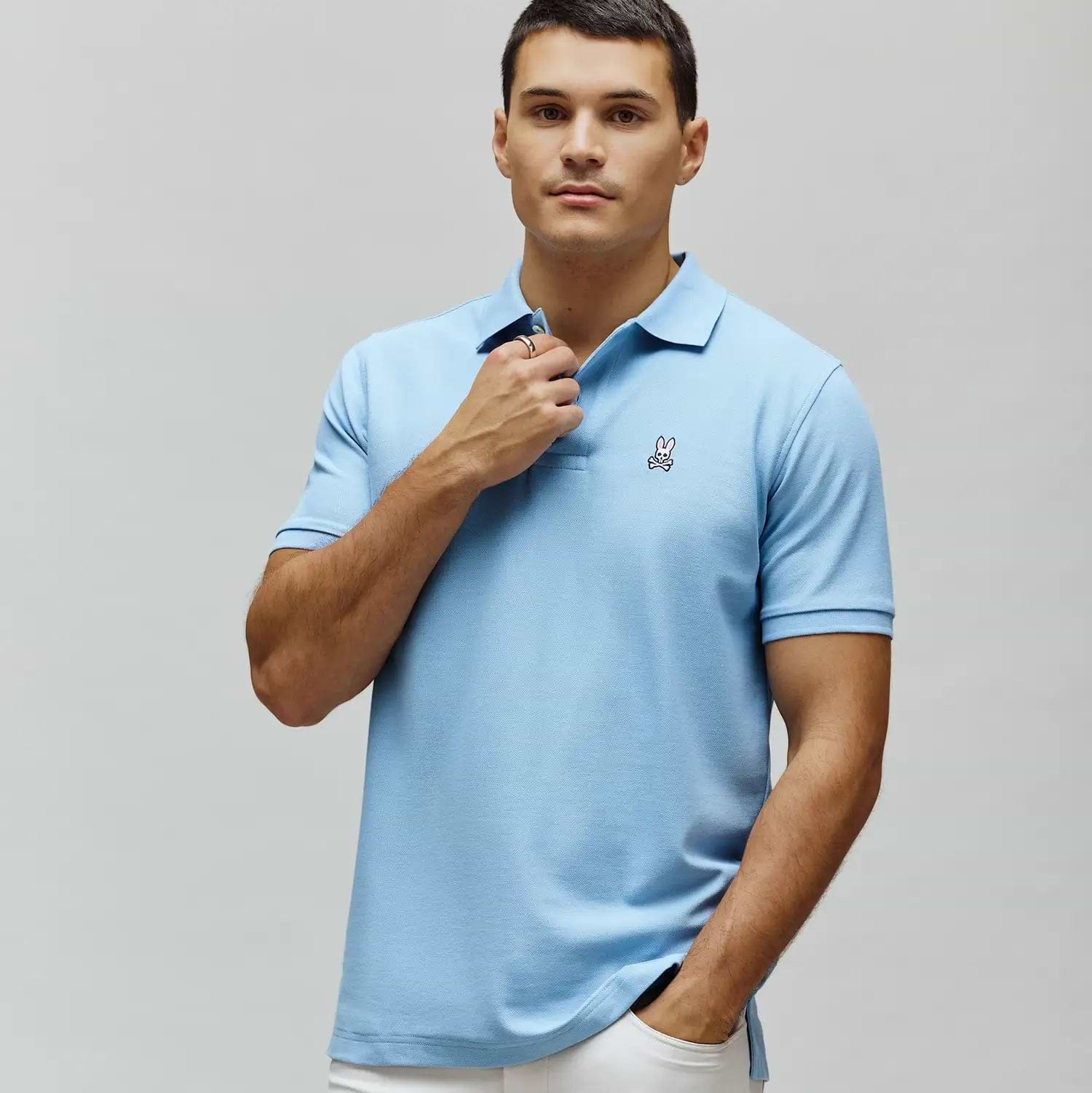 Light blue Mens Classic Pique Polo, a classic fit shirt with a small embroidered Psycho Bunny skull logo featuring pink ears and a white skull on the left chest.