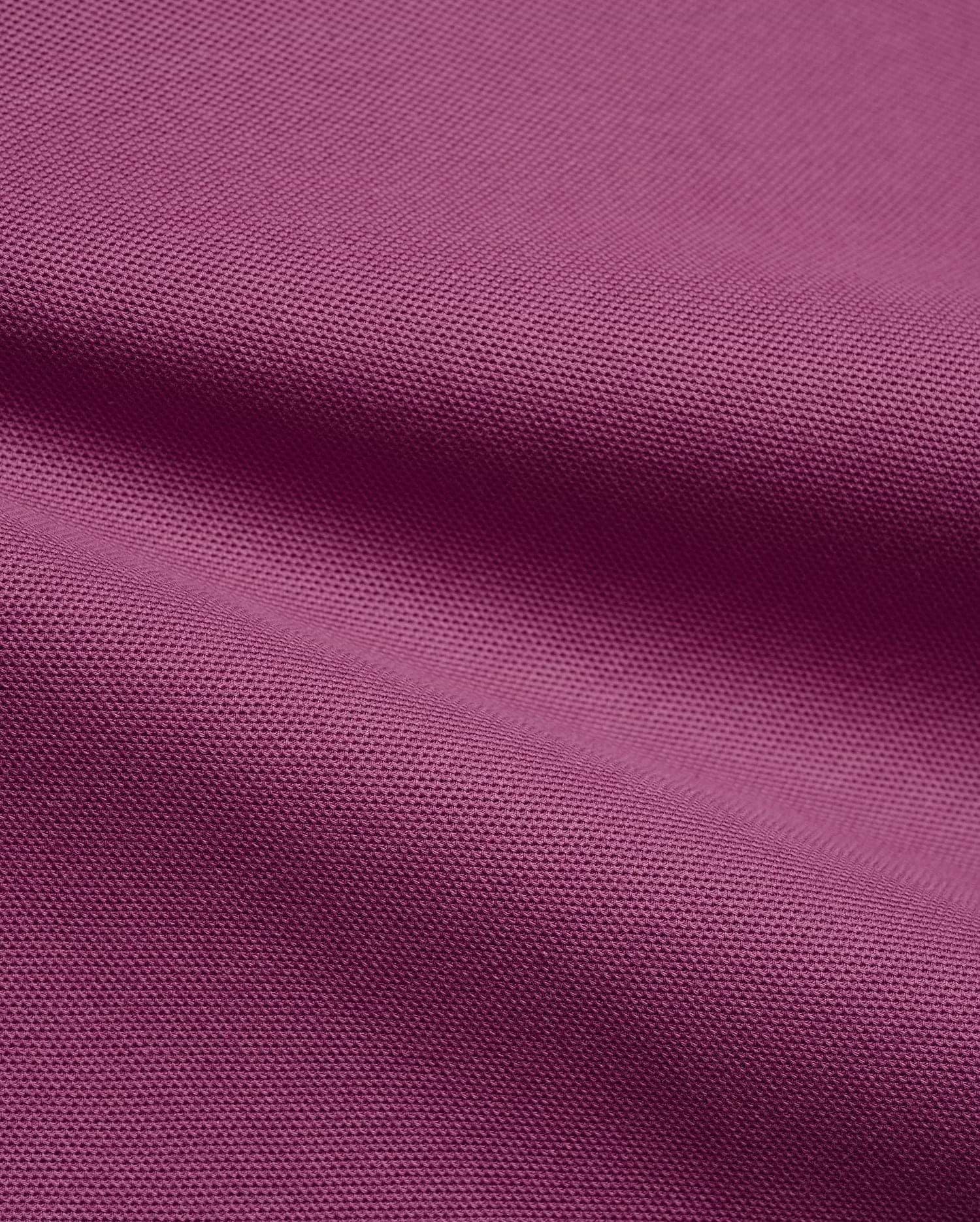 Psycho Bunny Mens Classic Pique Polo fabric in a vibrant deep magenta, highlighting the premium, breathable pique knit texture with elegant, soft folds, perfect for refined streetwear.