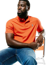 Men's Classic Pima Pique Polo in vibrant orange, featuring a classic fit, textured pique fabric, white two-button placket, and a small embroidered Psycho Bunny skull logo on the left chest. (3)