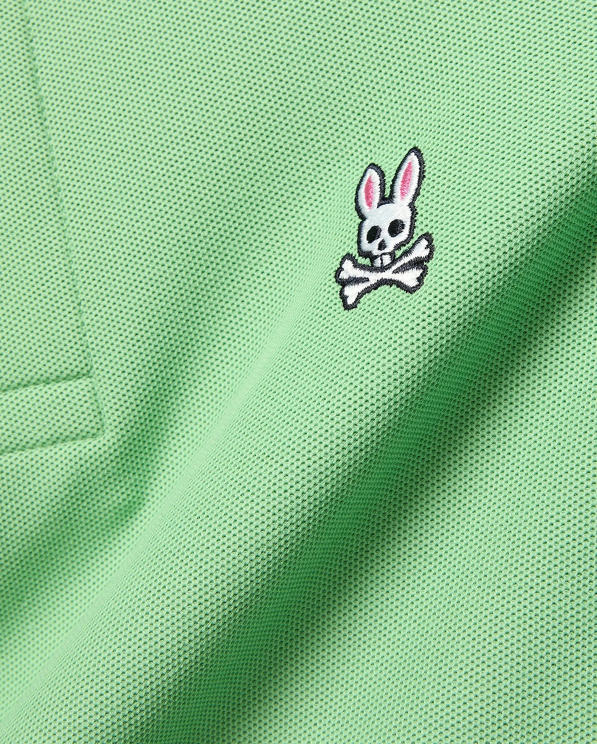 Mens Classic Pique Polo in vibrant light green, showcasing a detailed embroidered white, black, and pink Psycho Bunny skull logo on the left chest.
