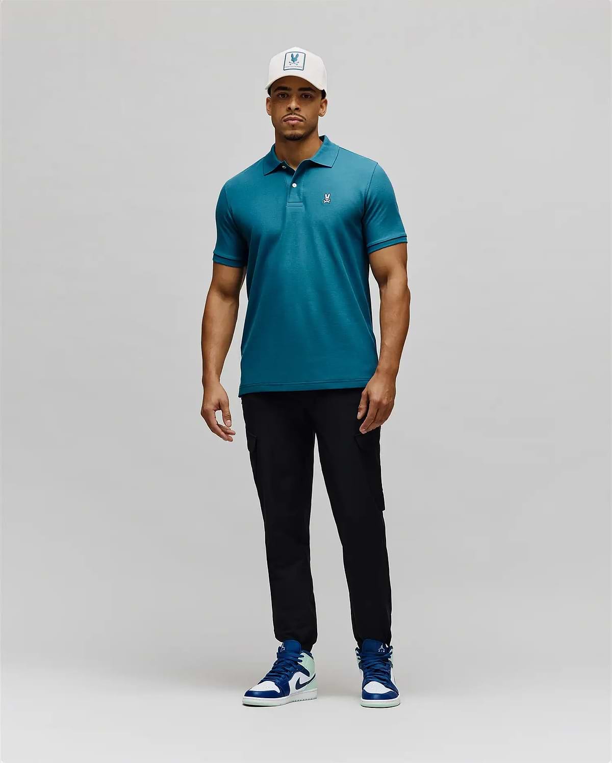 Mens Classic Pique Polo in vibrant teal pique fabric, featuring a classic fit, two-button placket, and a small white embroidered Psycho Bunny skull logo on the left chest. (5)