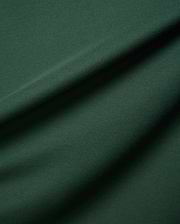Deep forest green Mens Classic Pique Polo fabric, highlighting the signature textured pique weave with elegant folds and shadows, reflecting Psycho Bunny's premium quality and refined streetwear style.